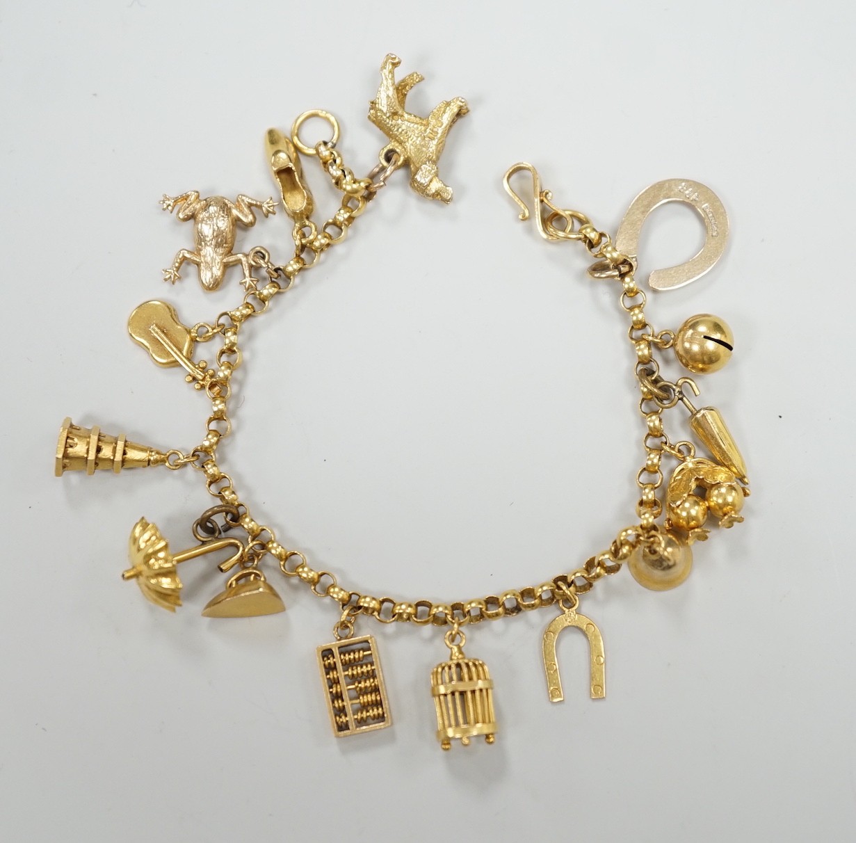 A Chinese yellow metal charm bracelet, hung with thirteen assorted yellow metal charms including four 9ct, 15.5cm